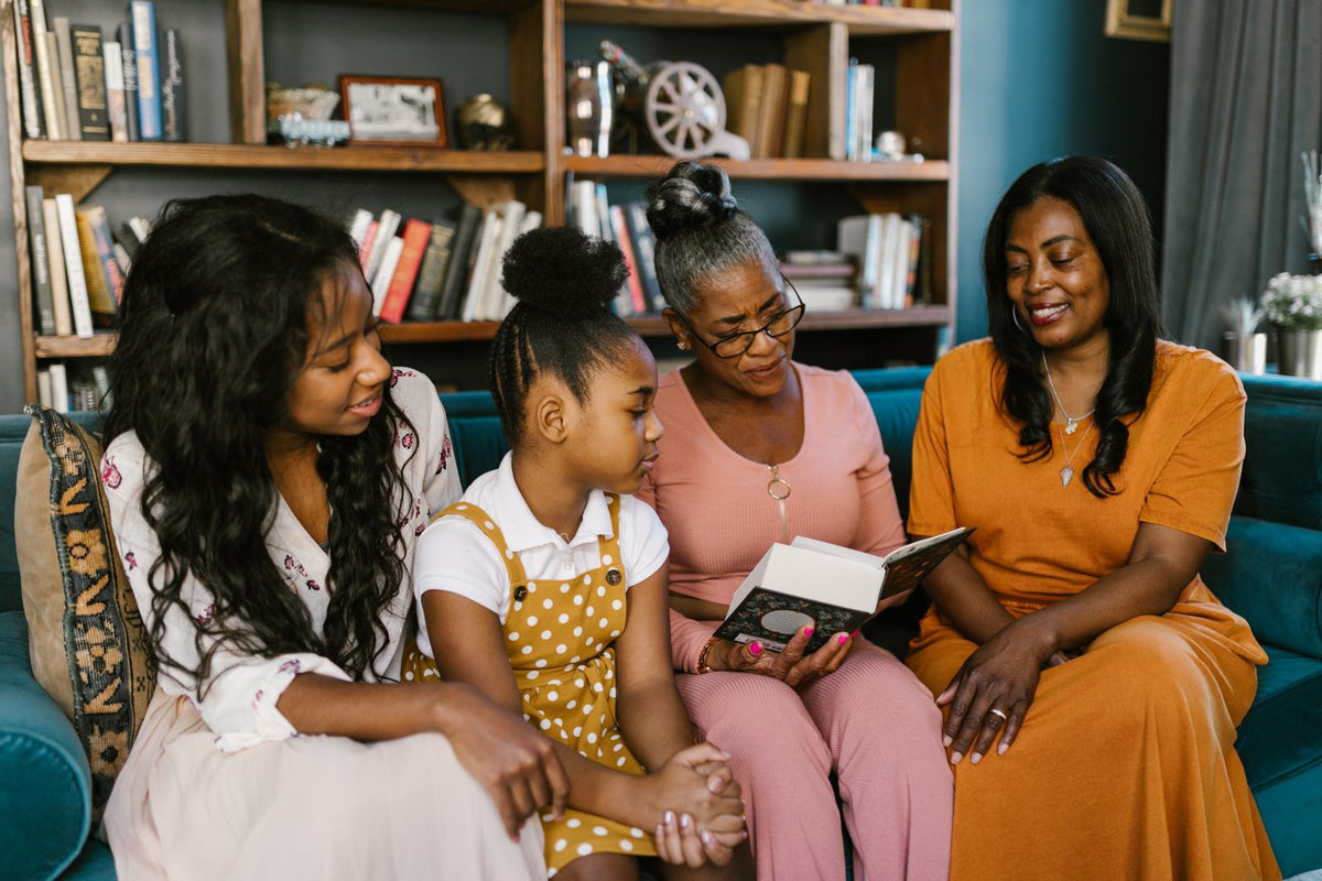 Three generations of a family sharing stories on the sofa at home